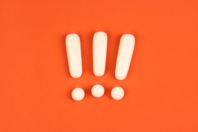 オレンジの背景の前にある白いビックリマーク